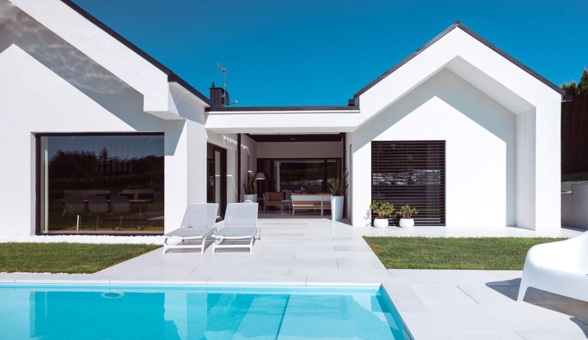 Scopri la villa minimal immersa nel verde con infissi Oknoplast: luce naturale, comfort e design senza barriere tra interno ed esterno.