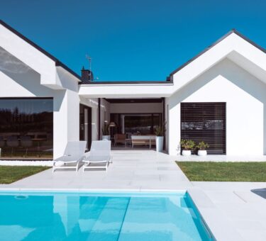 Scopri la villa minimal immersa nel verde con infissi Oknoplast: luce naturale, comfort e design senza barriere tra interno ed esterno.