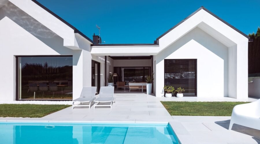 Scopri la villa minimal immersa nel verde con infissi Oknoplast: luce naturale, comfort e design senza barriere tra interno ed esterno.